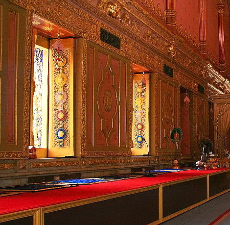 บานหน้าต่างพระวิหารสลักด้วยไม้เป็นลวดลายไทยจำลองรูปดวงตราเครื่องราชอิสริยาภรณ์  ผนังเป็นสีชมพู ผนังระหว่างช่องหน้าต่างทำเป็นรูปอุณาโลมสลับด้วยรูปอักษร “จ”