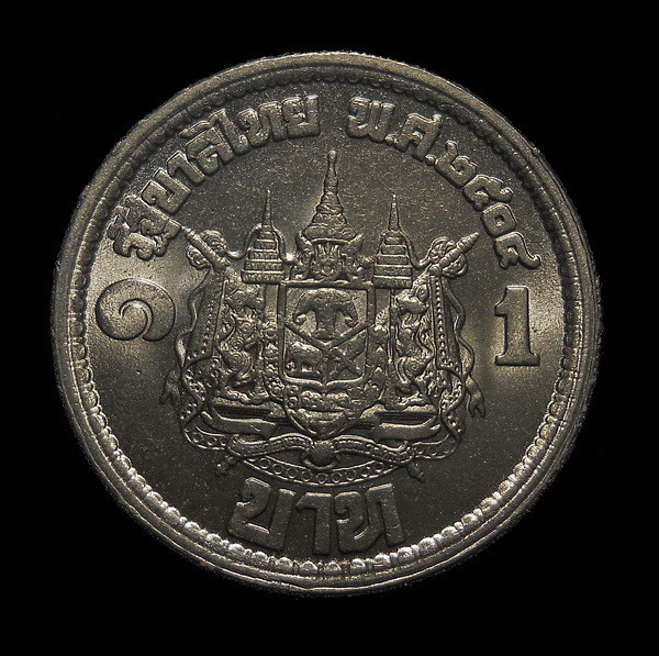 เหรียญ 1 บาท เสด็จนิวัตพระนคร ปี 04 เป็นเหรียญกษาปณ์ที่ระลึกเหรียญแรกนับแต่ทรงขึ้นครองราชย์ (K.60)