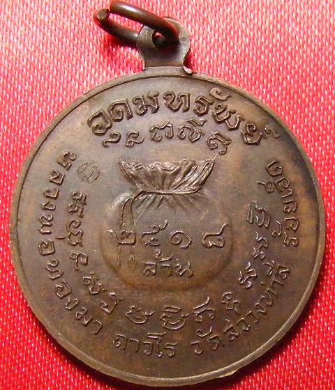 เหรียญอุดมทรัพย์หลวงปู่ทองมา ถาวโร วัดสว่างท่าสี จ.ร้อยเอ็ด ปี 2518 เนื้อทองแดง เลี่ยมเงิน