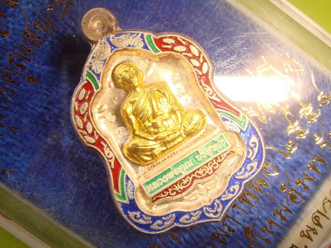 เหรียญรุ่นแรกของหลวงพ่อคูณโล่ห์เล็กออกวัดใหม่อัมพวันปี 2554 เนื้อเงินลงยาหน้าทองคำ หมายเลข 65