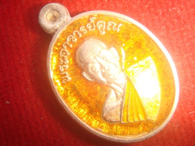เหรียญเม็ดแตง รุ่นอายุยืนครึ่งองค์ ออกวัดแจ้งนอกปี53 เนื้อเงินลงยาสีส้ม หมายเลข.311 สภาพสวย