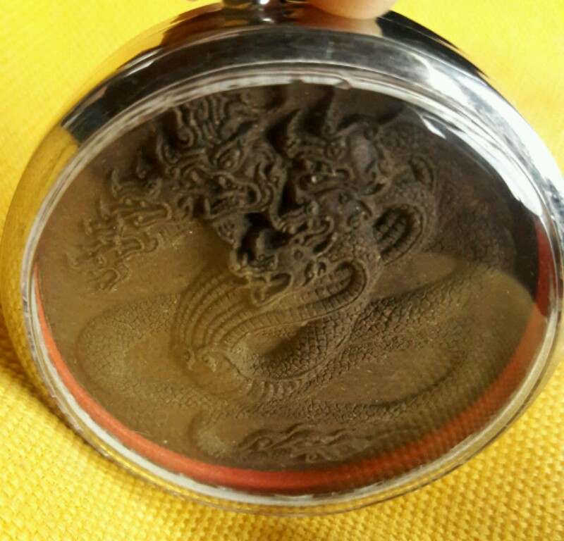 พญานาคเจ็ดเศียร ดวงตราพญาศรีสัตตนาคาธิบดี รุ่นแรก ปี พ.ศ.๒๕๔ ๙ ด้านหลัง ฝังปฐวีธาตุ หลวงปู่คำพันธ์ 