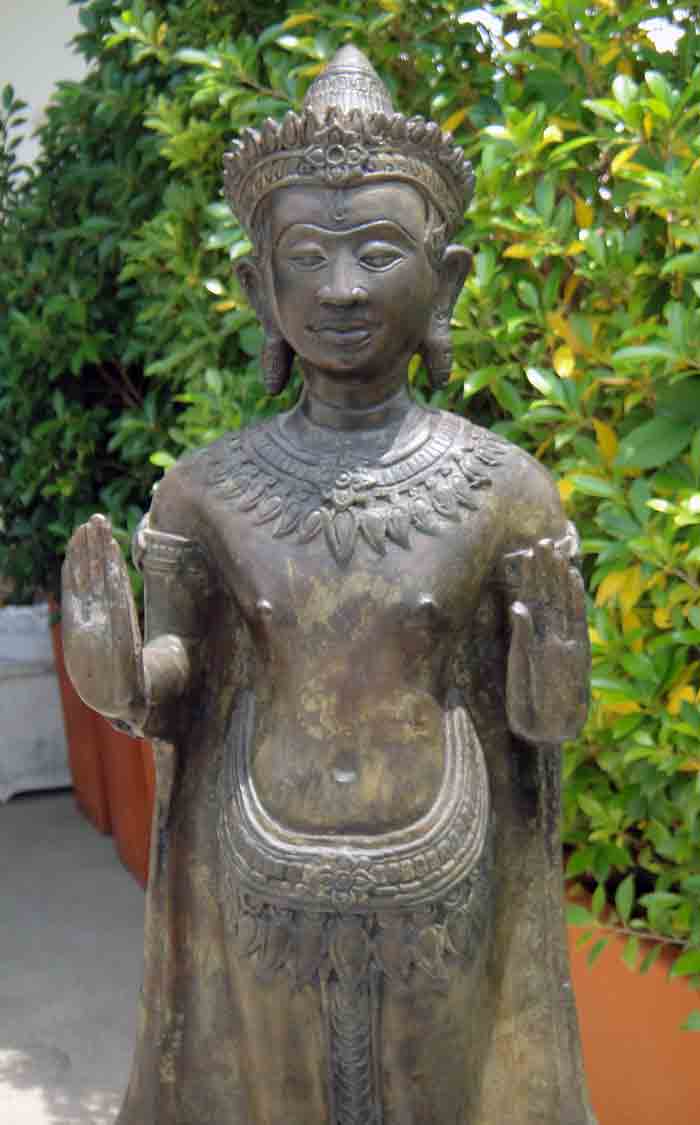 พระพุทธรูปทรงเครื่อง ปางห้ามสมุทร ยืนแสดงปางประทานอภัยทั้งสองพระหัตถ์ เนื้อโลหะผิวสนิมเขียว ศิลปะเขม