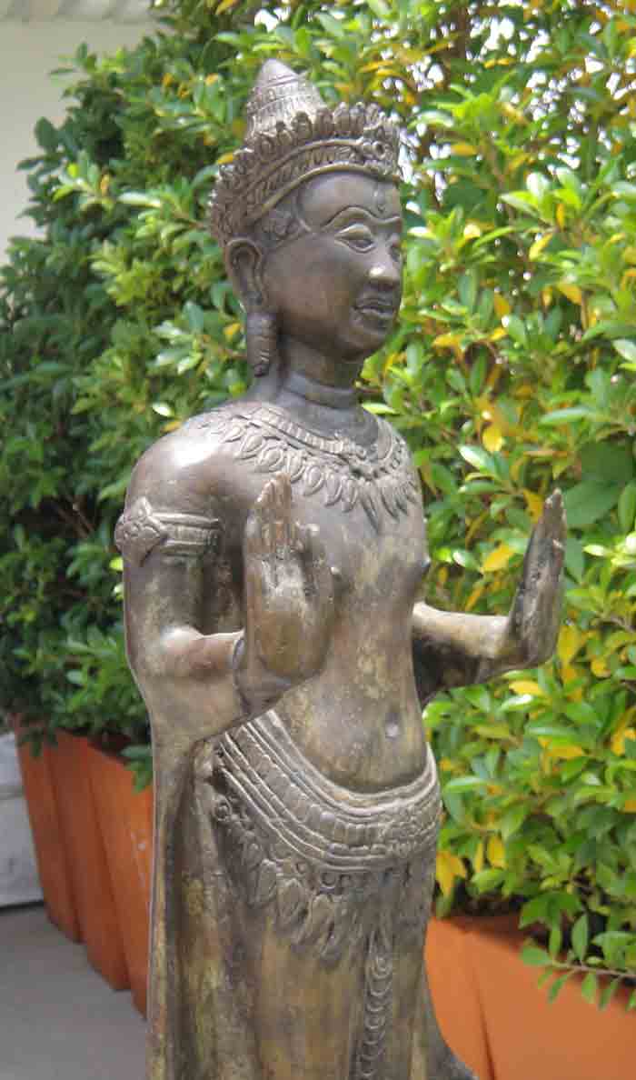 พระพุทธรูปทรงเครื่อง ปางห้ามสมุทร ยืนแสดงปางประทานอภัยทั้งสองพระหัตถ์ เนื้อโลหะผิวสนิมเขียว ศิลปะเขม