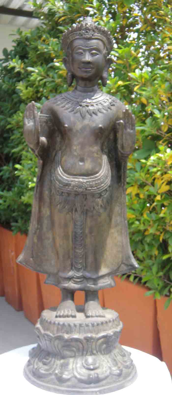 พระพุทธรูปทรงเครื่อง ปางห้ามสมุทร ยืนแสดงปางประทานอภัยทั้งสองพระหัตถ์ เนื้อโลหะผิวสนิมเขียว ศิลปะเขม