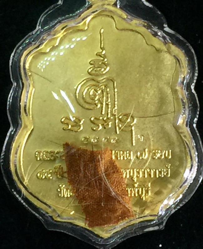 เหรียญเสมาลงยาสีแดง หลวงพ่อจรัญ วัดอัมพวัน รุ่น 7 รอบ ปี 54 เลี่ยมใส่เกศาและจีวร เลข 9899