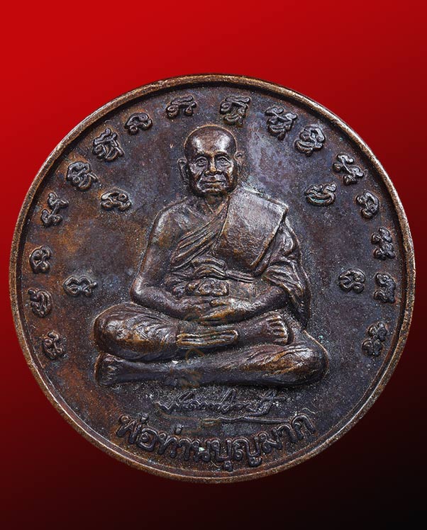 เหรียญพ่อท่านบุญมาก หลังจตุคามรามเทพ  อักขระด้านหน้ารายล้อมด้วยพระคาถาพระเจ้า ๑๖  พระองค์