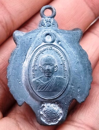 หัวเสือเขี้ยวดาบหลังรูปเหรียญเม็ดเเตงหลวงพ่อสุด