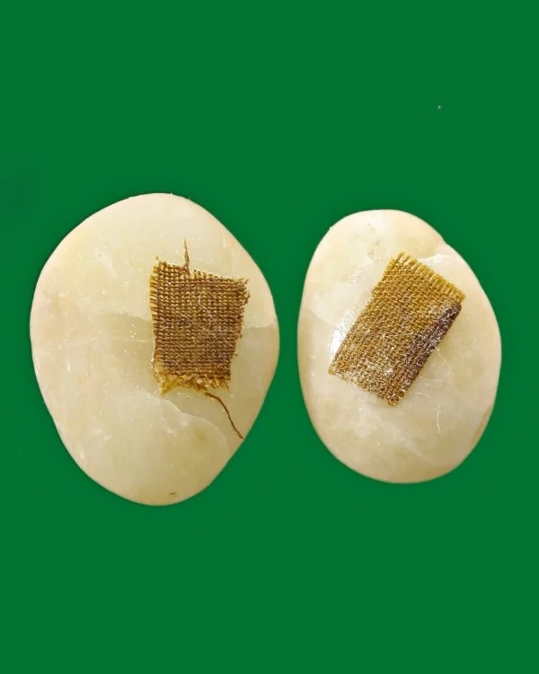 ปัฐวีธาตุติดผ้าจีวรหลวงปู่คำพันธ์ ๒ เม็ด