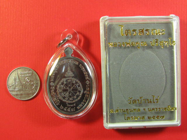 เหรียญไตรสรณะ  หลวงพ่อคูณ วัดบ้านไร่  ไตรมาส ปี๒๕๕๗  เนื้อทองแดงรมดำ เลี่ยมพลาสติก หมายเลข ๙๑๒ 