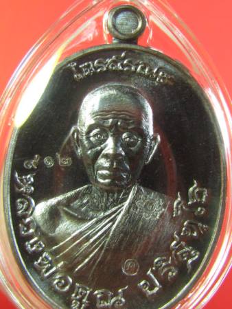 เหรียญไตรสรณะ  หลวงพ่อคูณ วัดบ้านไร่  ไตรมาส ปี๒๕๕๗  เนื้อทองแดงรมดำ เลี่ยมพลาสติก หมายเลข ๙๑๒ 