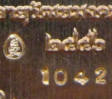 เหรียญจตุรพิธพรชัย หลวงปู่คำพันธ์ วัดหนองบัวสร้าง จ.สกลนคร ปี2556 เนื้อทองฝาบาตร ตอกโค้ด  หมายเลข