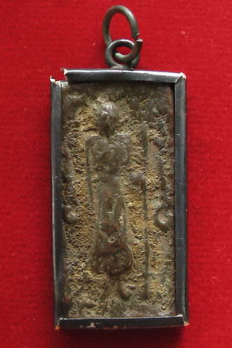 หลวงปู่ศุขยืนถือไม้เท้า ข้างอุ หลังยันต์นูน